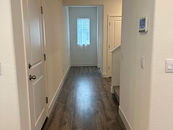 Hallway from dining/kitchen to downstairs office/bedroom. Entry to garage is the first door to the left