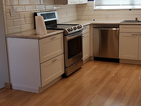 Kitchen with new countertops, professional range hood, and dishwasher