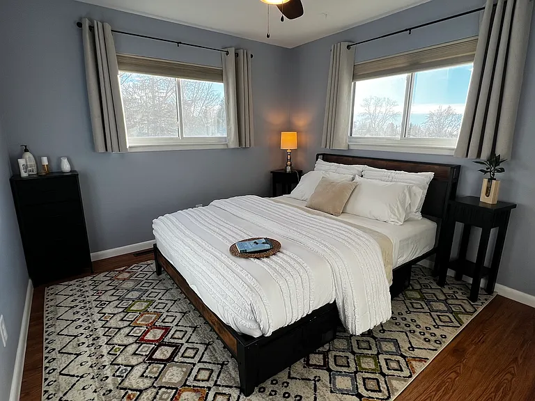 Comfortable queen bedroom with natural light and convenient under-bed storage for extended stays.