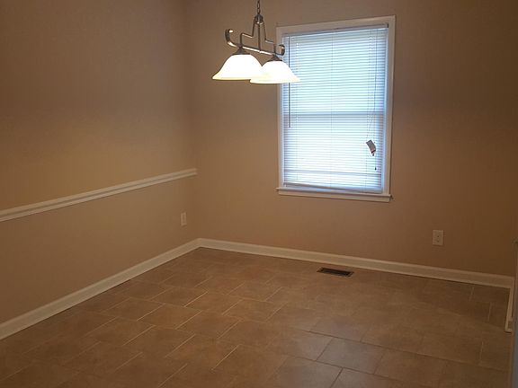 Dining room with chair rail molding and tile flooring