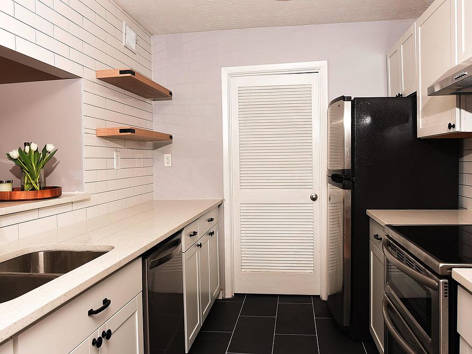 Beautiful, brand new gallery kitchen, subway tile wall with floating shelves, door to large food pantry.