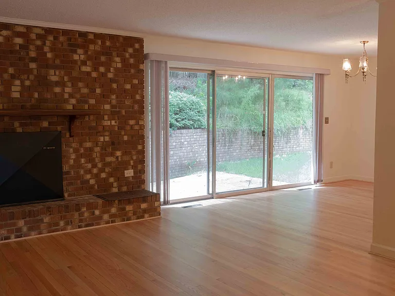 Living room and dining room, with large sliding door and newly refinished oak floors.