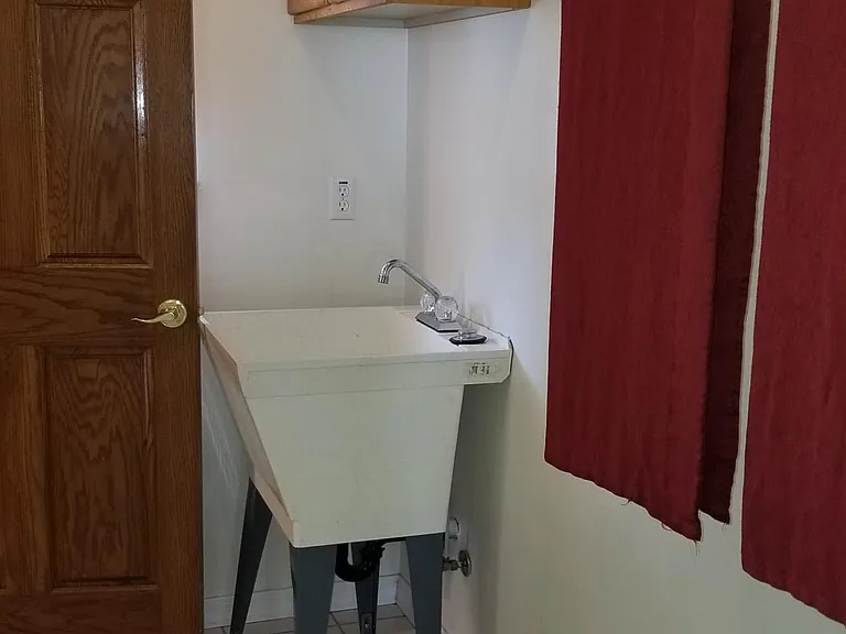 Wash room with washer and dryer hookups and large utility sink.