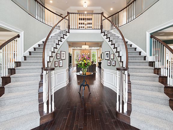 Dramatic entry foyer with dual curved staircases