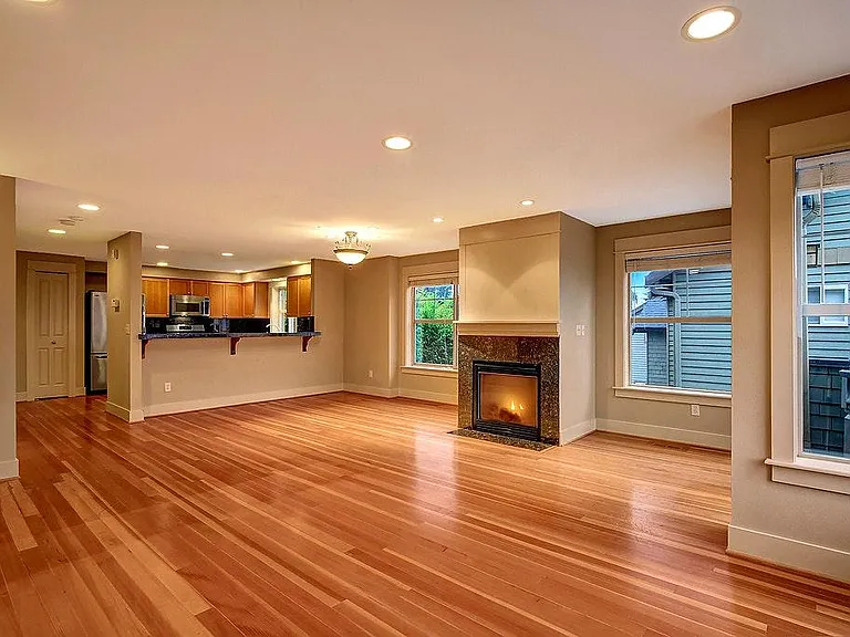 Spacious living room with kitchen and gas fireplace.