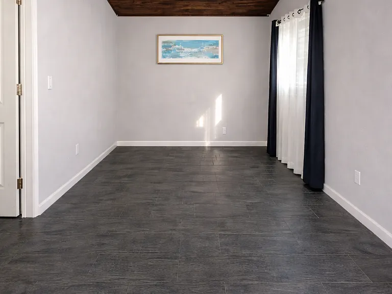 Livingroom , vaulted ceiling, tile floor. small living room best suited for a compact L-shaped sectional or a medium size couch. Look at the next picture with furniture (staged) It gives a cozy feeling.