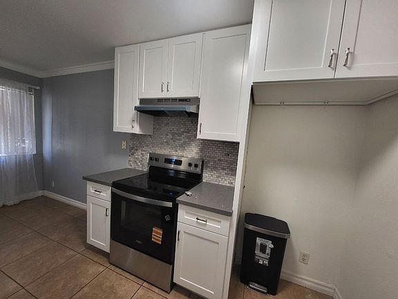 Enjoy cooking in this beautifully updated kitchen, featuring brand new, just-installed white cabinets and a brand new stainless steel range. The modern look is completed with new grey countertops and a stylish tile backsplash.