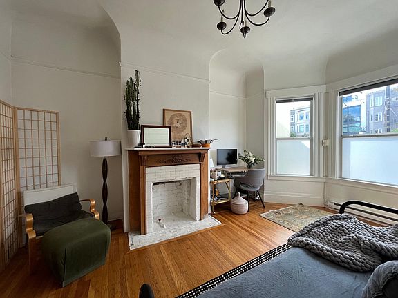 Studio main living area with decorative fireplace and windows with view to Twin Peaks.