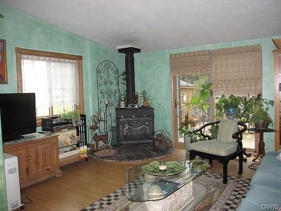 The living room. The blinds cover the sliding glass door. The wood stove can heat he entire home.