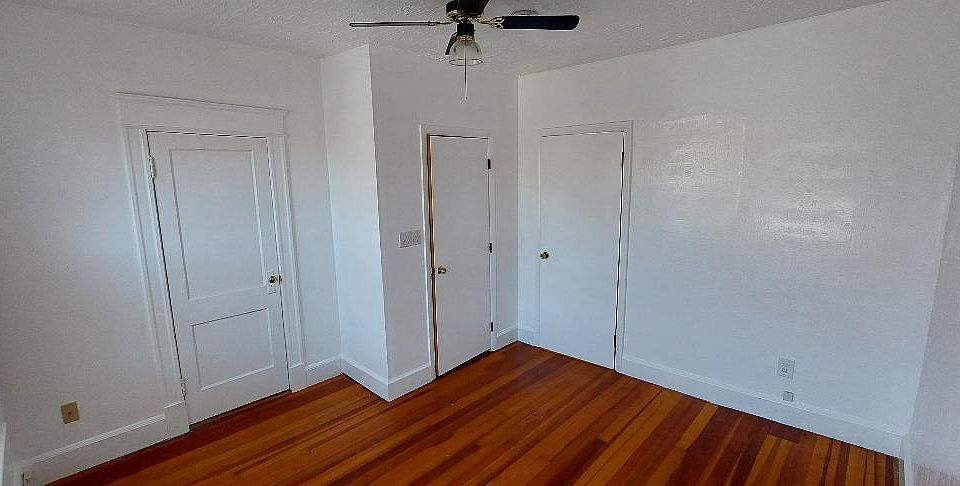 Bedroom, left door to bathroom, middle door to closet, right door to kitchen, with paddle fan.