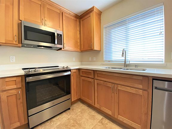 Kitchen with stove, oven, microwave, dishwasher, double-sink, and garbage disposal. Plenty of cabinet storage.