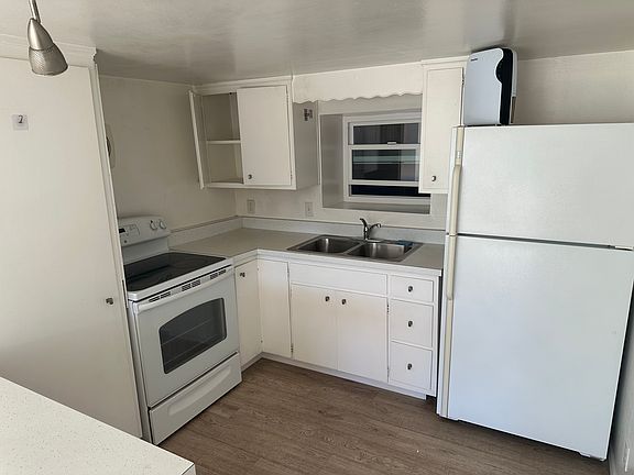 Kitchen with refurbished fridge and electric stove/oven.