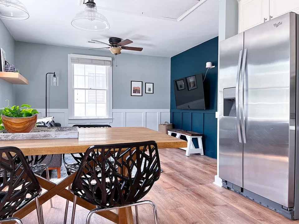 Bright, modern kitchen and dining area with natural light and updated stainless appliances.