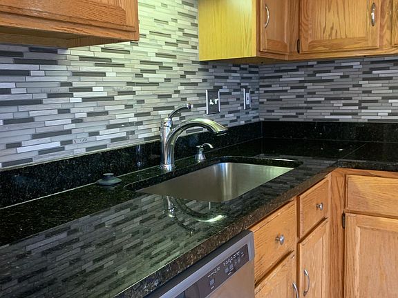 Remodeled kitchen with stainless appliances and granite countertops.