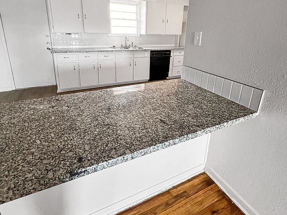 A modernized bar counter separates the kitchen and living room