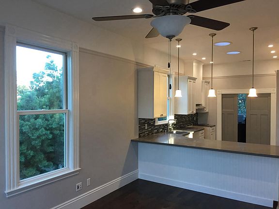 Open concept living/kitchen room with high ceilings.