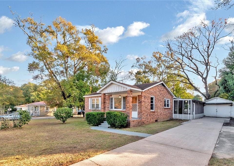 A one-family all-brick home sitting on a large fenced lot with a wrap around screen porch and garage.