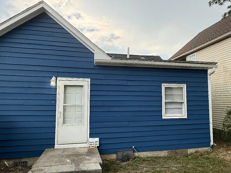 Back of the house with back door and second bedroom window.