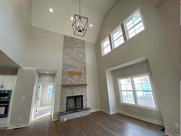 Living room with stone surround gas fireplace and vaulted ceilings
