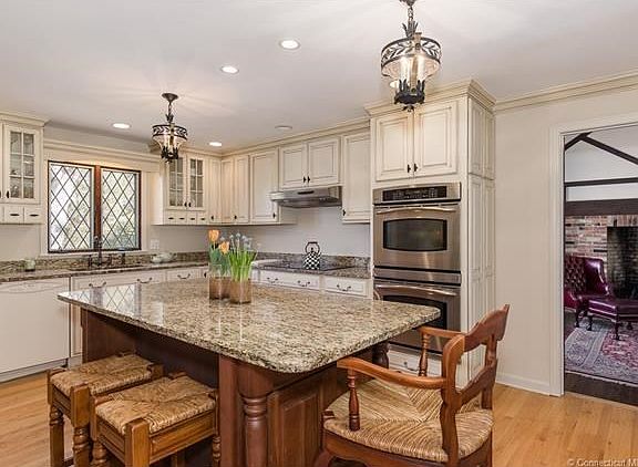 New kitchen with granite counters and center island and antique white country cabinets. (The kitchen is adjacent to the family room.)