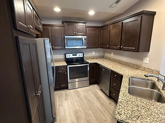MODERN KITCHEN WITH STAINLESS STEEL APPLIANCES AND SOLID SURFACE COUNTERTOPS