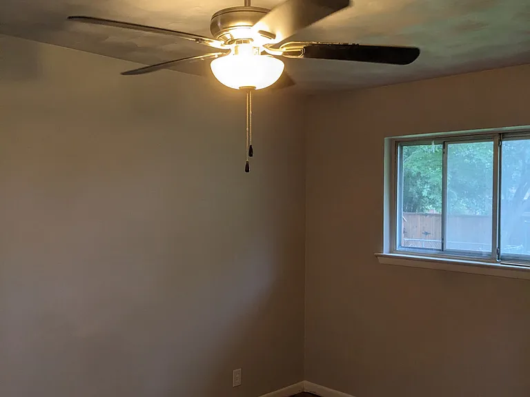 Bedroom view focusing on ceiling fan light. Hardwood floors.