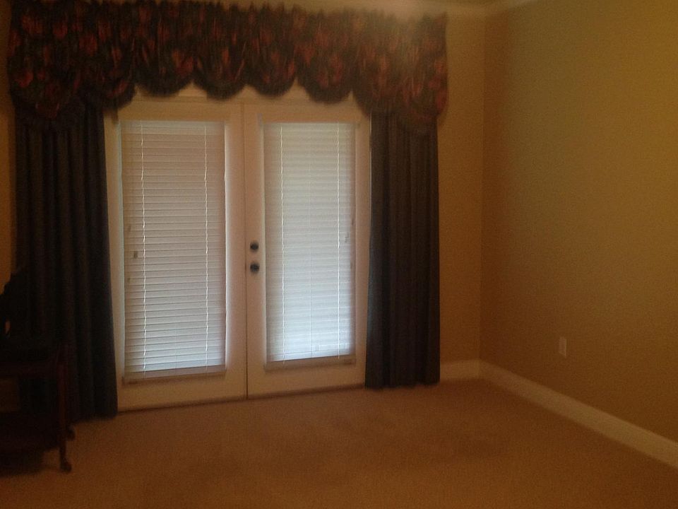 first bedroom with patio doors that open to porch. designer