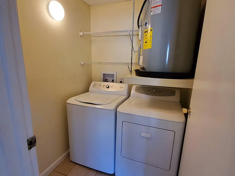 Walk in Laundry Room with storage shelves.