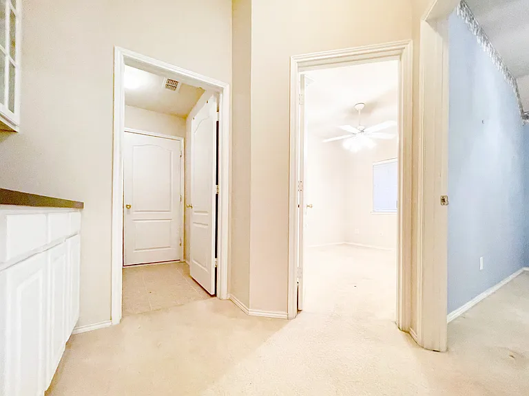 Hallway leading to two bedrooms, Laundry Room, and 2-car Garage