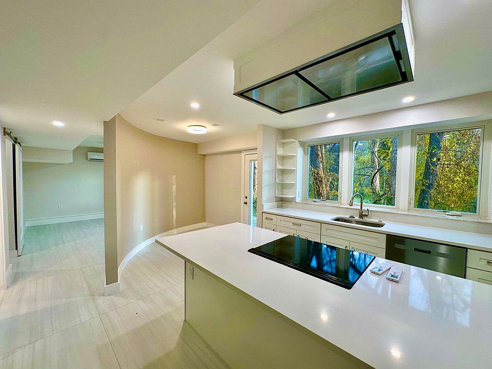 Kitchen on right, breakfast area along curved wall by front door, and bedroom on left