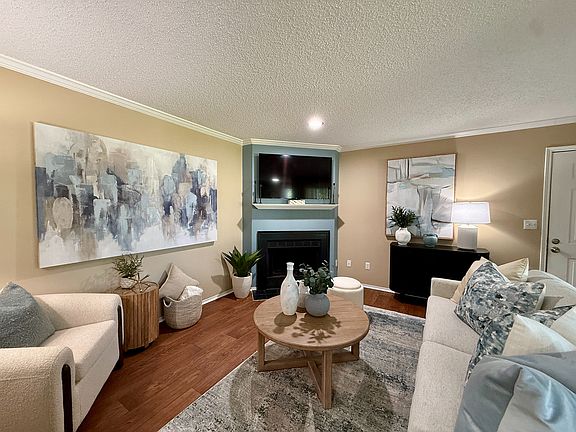 Spacious living room with hardwood-style flooring & fireplace