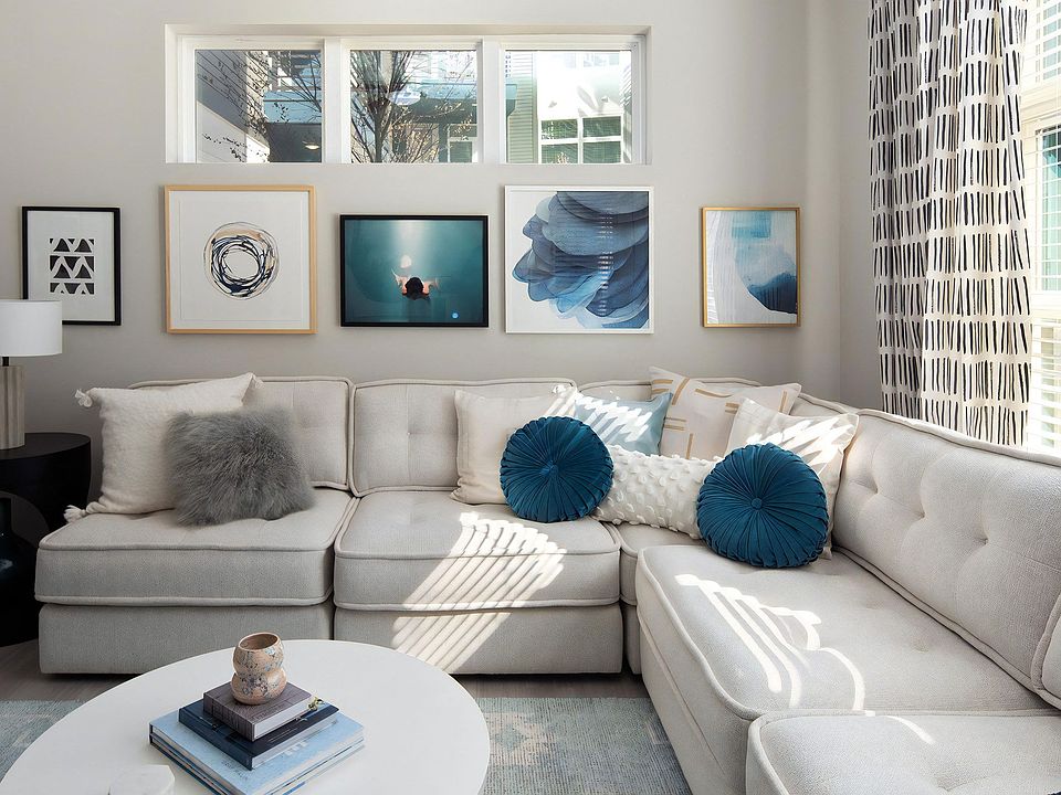 Living Room with Large Sectional Sofa, Framed Art, and Natural Light from Wide Windows