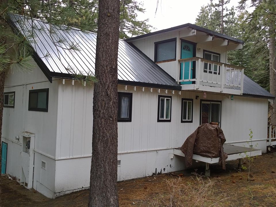back of house w/ view of upper bedroom/office deck and kitchen deck