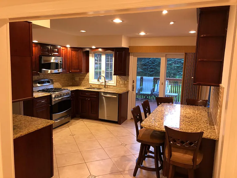 Updated kitchen with granite countertops, stainless steel appliances, and recessed lighting.
