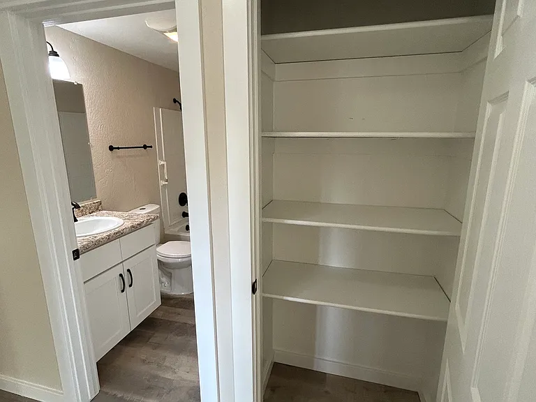 Bathroom on left of hallway, next to second hallway storage closet