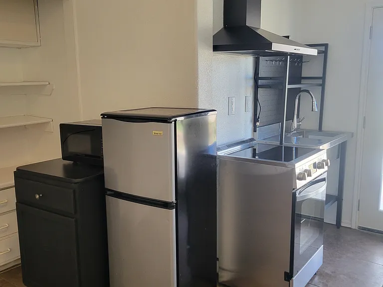 New microwave, kitchen countertop and fridge with freezer.