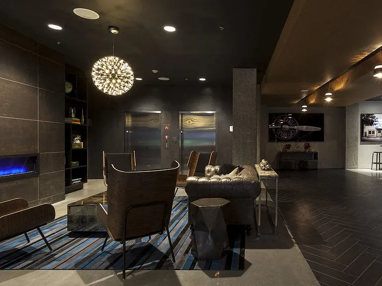 Community Lounge with Armchairs, Fireplace, and Overhead Lighting