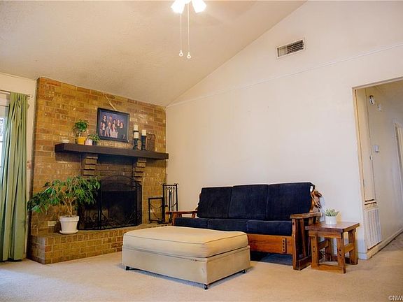 Large family room with a wood-burning fireplace and vaulted ceiling.