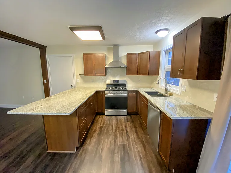 Updated kitchen featuring granite counters that seat at least 4 people. Updated stainless steel appliances featuring a gas convection range, range hood, French door refrigerator, and inSINKerator quiet disposal.