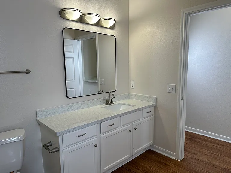 Elegant bathroom with modern fixtures, featuring a sleek vanity, large mirror, and ample lighting. Elegant bathroom with modern fixtures, featuring a sleek vanity, large mirror, and ample lighting.