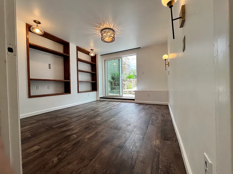 On ward to Bedroom 2. Natural light pouring in from the sliding glass door to the backyard. +Built in shelves again.