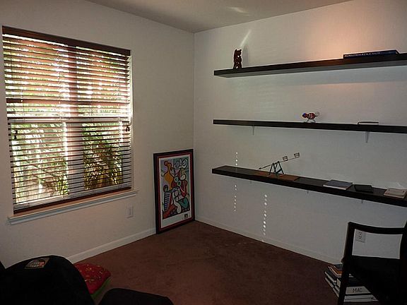 Study with carpeted flooring and shelving