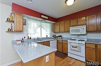 Kitchen features breakfast bar, solid surface counter tops, lots of cabinets