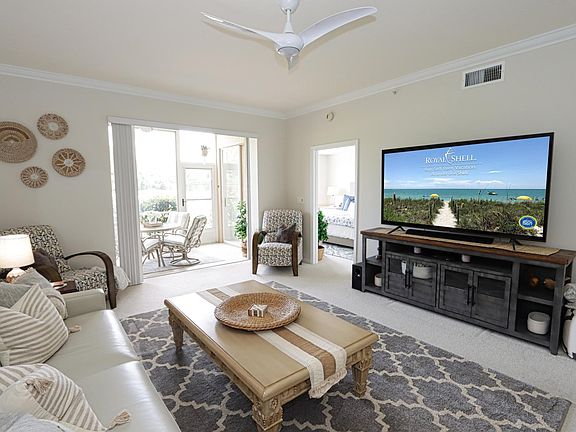 Spacious living area w/queen sleeper sofa, large TV, and small built-in bar ... This area can be expanded into the enclosed back lanai by opening the sliding stacker doors.