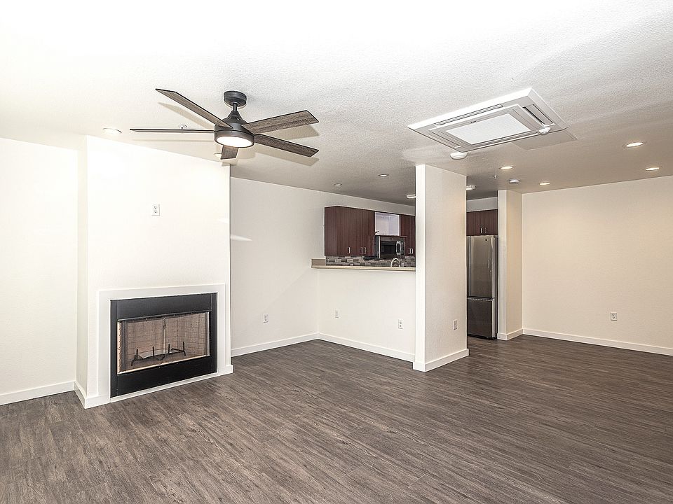 living room featuring ceiling fan, wood-type flooring, and a textured ceiling