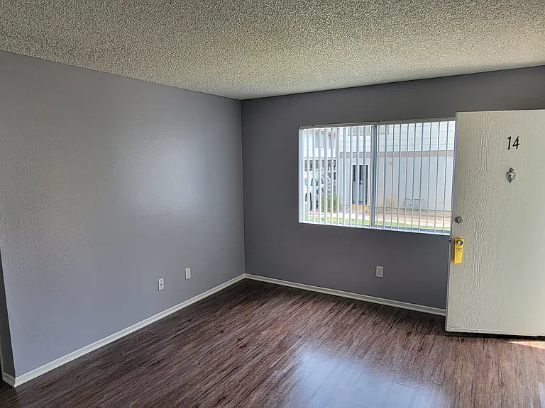 Front room with hardwood flooring and lots of natural light at Grand Oaks Apartments in Lake Elsinore, California.