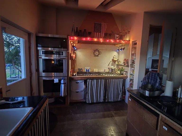 Large kitchen area includes 8-burner gas stove, dual electric ovens; microwave oven, cooking and baking utensils included.