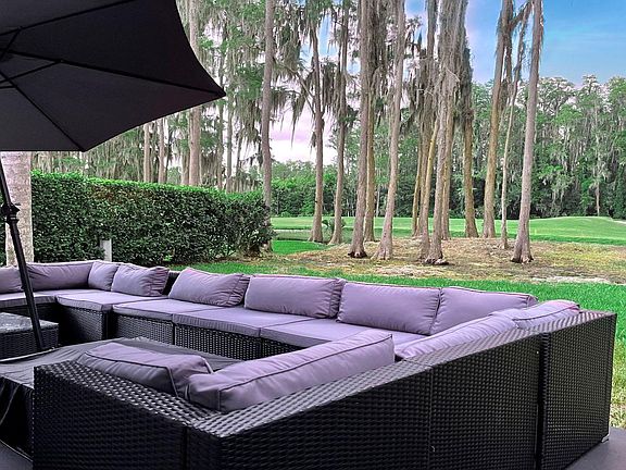 Back garden with outdoor living room style patio area overlooking lake and Saddlebrook Golf Resort Course.