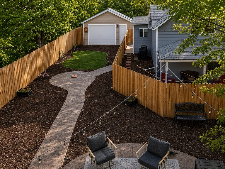 Large backyard with stamped concrete patios and walkway, bistro lights, full xeriscape, fully fenced and 2 car garage.
