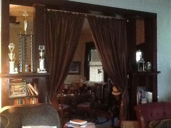 View from the front door into the living room and through the wooden arch to the dining room. Notice the 11' walls. This area could also be transformed into a comfortable greeting area adjoining several independent offices or beauty salon--use your i